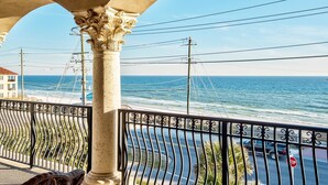 Un balcon donnant sur l’océan, avec une balustrade et une colonne.