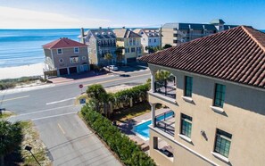 A coastal residential area with a street, a stop sign, and a building with a swimming pool. - Casa Tuscany 6 Bedroom Holiday Home by Five Star Properties (Miramar Beach)