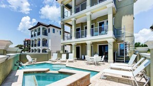 A multi-story hotel with a swimming pool and outdoor seating area. - DaShells30A 6 Bedroom Holiday Home by Five Star Properties (Santa Rosa Beach)