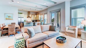 A spacious living room with a sofa, coffee table, and dining area. - DaShells30A 6 Bedroom Holiday Home by Five Star Properties (Santa Rosa Beach)