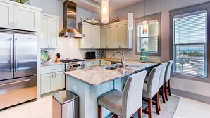 A modern kitchen with a central island, stainless steel appliances, and pendant lighting. - DaShells30A 6 Bedroom Holiday Home by Five Star Properties (Santa Rosa Beach)
