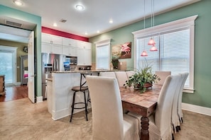 Enjoy meals in the kitchen and dining area, featuring a central island, stainless steel appliances, and a wooden table with four chairs.