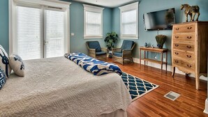 Ein Schlafzimmer mit einem großen Bett, einem Deckenventilator, einem Holzschrank und einem Fernseher.