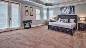 A bedroom with a large bed, a ceiling fan, and a painting on the wall. - Destination Fun 9 Bedroom Holiday Home by Five Star Properties (Destin)