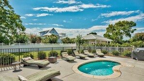 A backyard with a swimming pool, lounge chairs, and a fenced area. - Destination Fun 9 Bedroom Holiday Home by Five Star Properties (Destin)