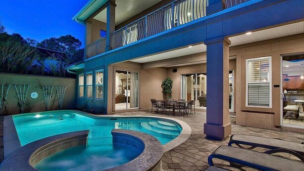 A two-story house with a swimming pool, outdoor seating, and a balcony. - Destiny Tranquility 5 Bedroom Holiday Home by Five Star Properties (Destin)