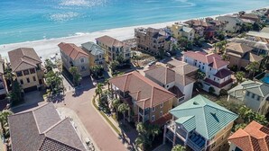 Ett bostadsområde vid kusten med hus, en strand och en fri utsikt över havet.