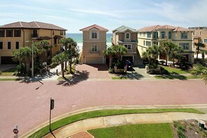 A residential area with multiple two-story houses, a paved street, and palm trees. - Dolce Vita 6 Bedroom Holiday Home by Five Star Properties (Destin)
