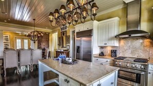 A spacious kitchen with a large island, stainless steel appliances, and a chandelier. - Dream Weaver 5 Bedroom Holiday Home by Five Star Properties (Santa Rosa Beach)