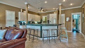 A spacious kitchen with a central island, white cabinets, and a ceiling fan. - Emerald Enchantment 4 Bedroom Holiday Home by Five Star Properties (Destin)