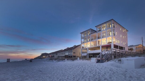 A multi-story beachfront building with balconies and a staircase leading to the beach. - Soleil et Mer 13 Bedroom Holiday Home by Five Star Properties (Destin)