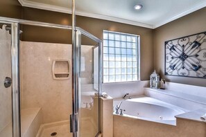 A modern bathroom with a glass-enclosed shower, a large bathtub, and a decorative wall piece. - Son Kissed 4 Bedroom Holiday Home by Five Star Properties (Destin)