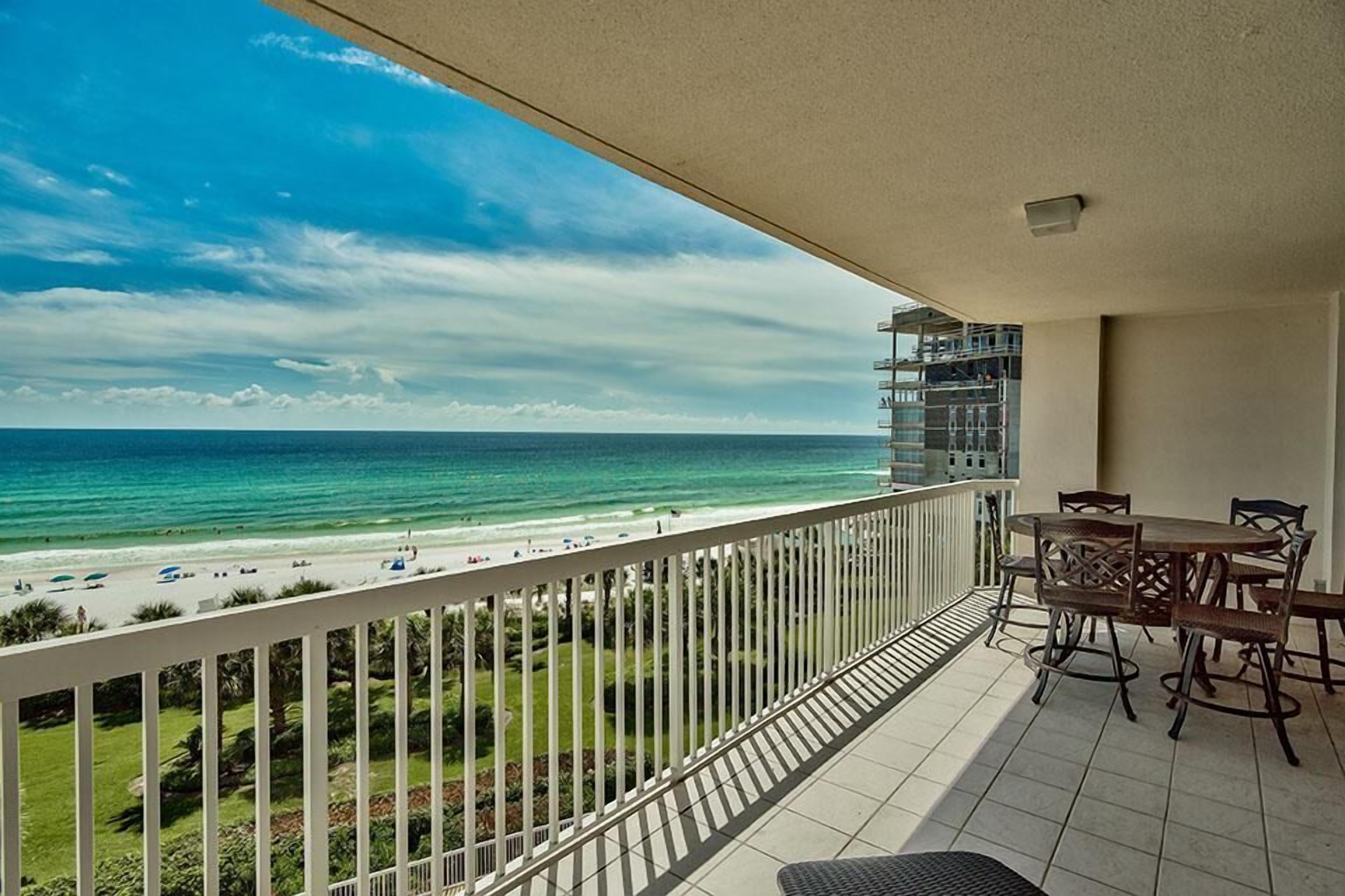 Un balcón con vista a la playa y al océano.