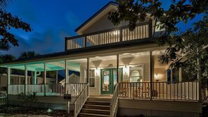 A two-story house with a covered porch and a staircase leading to the entrance.