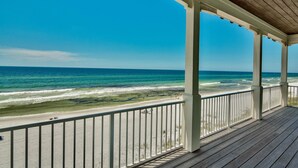 Une terrasse en bois offrant une vue sur la plage et l’océan.