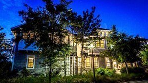 A large, multi-story building with a classic architectural style, featuring a prominent entrance and multiple windows. - The Flagship of Watersound 5 Bedroom Holiday Home by Five Star Properties (Santa Rosa Beach)