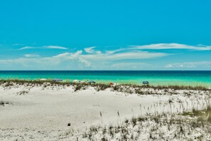 A beach with white sand and sparse vegetation. - The White House of Holiday Isle 6 Bedroom Holiday Home by Five Star Properties (Destin)