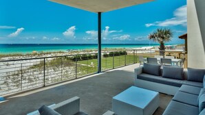 A balcony with outdoor seating overlooking a beach and ocean. - The White House of Holiday Isle 6 Bedroom Holiday Home by Five Star Properties (Destin)