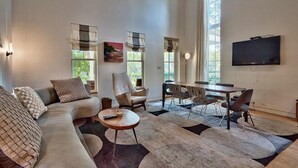 Una sala de estar moderna con un sofá, sillones, una mesa de centro y un comedor.