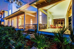 A modern house with a covered porch, large windows, and outdoor seating. - The White House of Watercolor 4 Bedroom Holiday Home by Five Star Properties (Santa Rosa Beach)