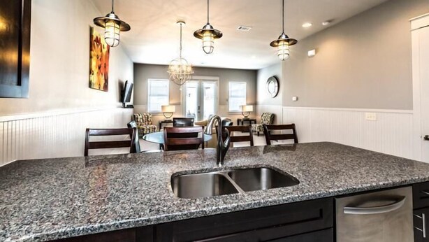 A kitchen with granite countertops, stainless steel sink, and pendant lighting. - VILLA DEL CARMEN 5 Bedroom Holiday Home by Five Star Properties (Miramar Beach)