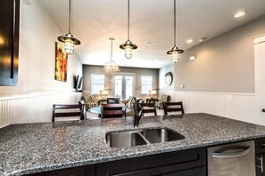 A kitchen with granite countertops, stainless steel sink, and pendant lighting. - VILLA DEL CARMEN 5 Bedroom Holiday Home by Five Star Properties (Miramar Beach)