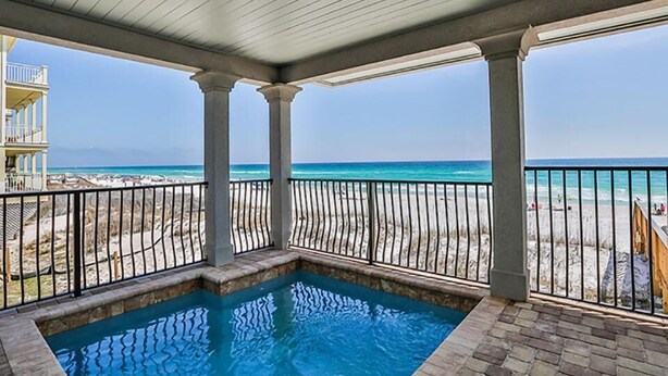 A covered swimming pool with a view of the beach and ocean.