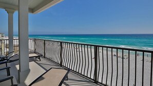 A balcony with a view of the beach and ocean.