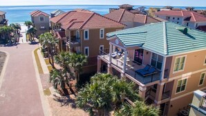 A coastal residential area with multi-story buildings, balconies, and palm trees. - Honu Hale 5 Bedroom Holiday Home by Five Star Properties (Destin)