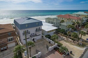 Un área residencial costera con casas, una playa y una vista despejada del océano.