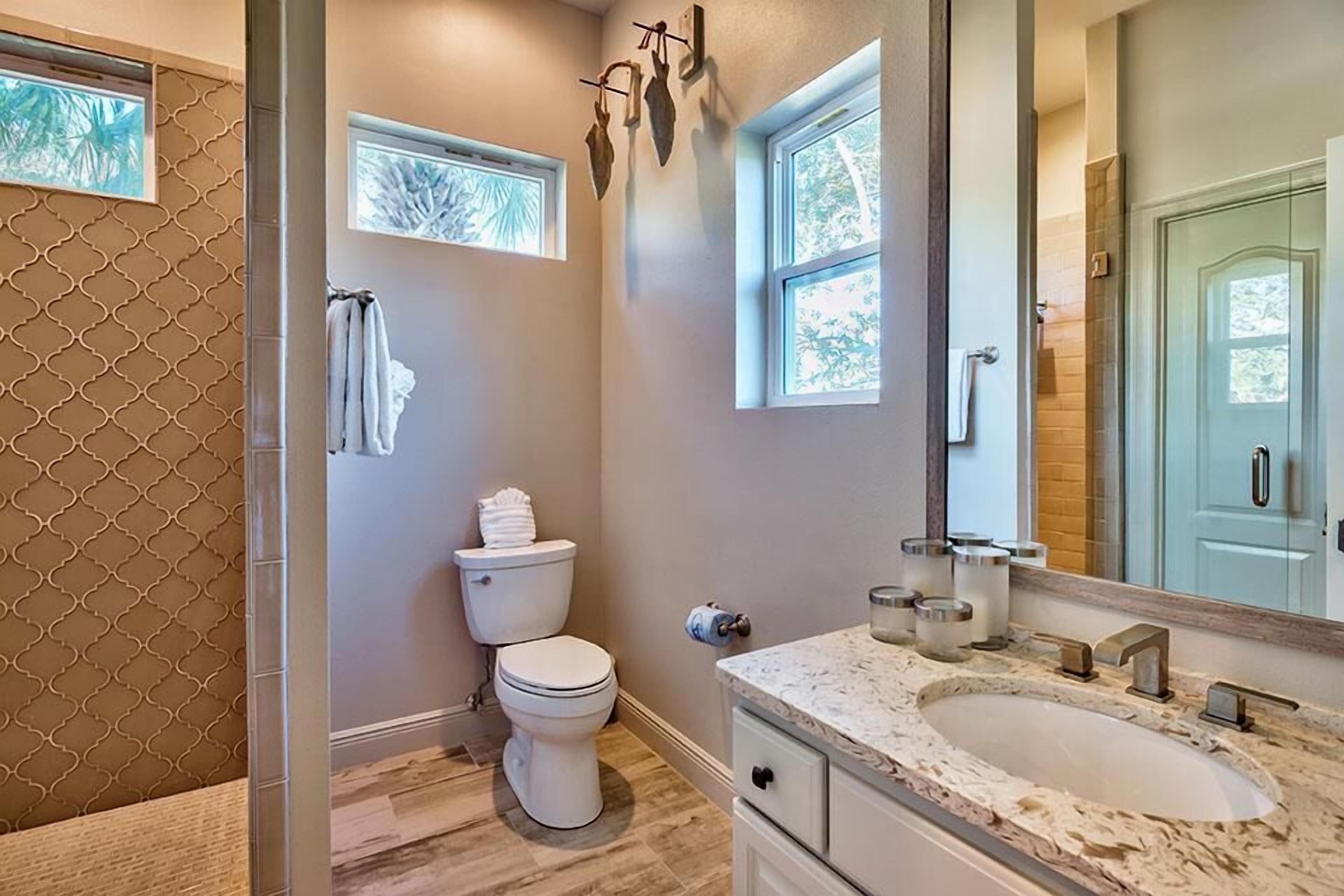 A bathroom with a toilet, sink, and shower.