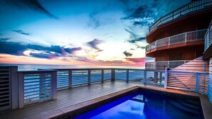 A pool area with a view of the ocean and a sunset. - Kates Porch 7 Bedroom Holiday Home by Five Star Properties (Miramar Beach)