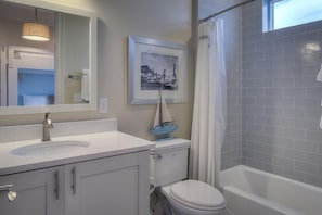 Un baño con lavamanos, inodoro y bañera.