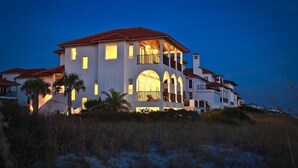 A large, multi-story house with a red roof, multiple balconies, and arched windows. - Laissez Faire 5 Bedroom Holiday Home by Five Star Properties (Santa Rosa Beach)