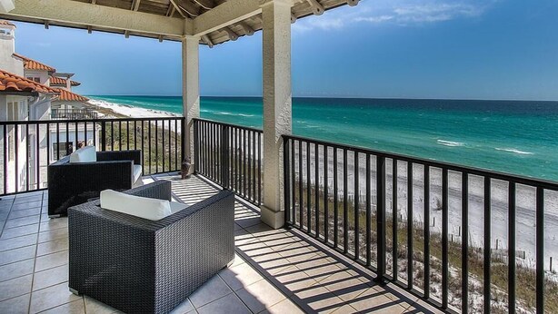 A covered outdoor area with a view of the ocean, featuring a seating area with a table and chairs. - Laissez Faire 5 Bedroom Holiday Home by Five Star Properties (Santa Rosa Beach)