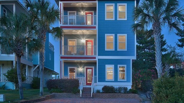 Um edifício residencial de vários andares com fachada azul, varanda frontal e uma varanda no segundo andar.
