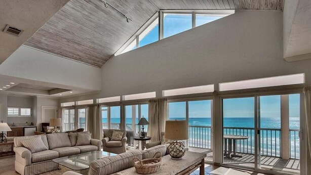 A spacious living room with a large glass door leading to a balcony overlooking the ocean. - Luna Sea 4 Bedroom Holiday Home by Five Star Properties (Santa Rosa Beach)