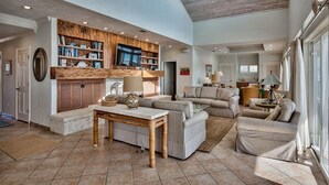 A spacious living area with a large sofa set, a coffee table, and a bookshelf. - Luna Sea 4 Bedroom Holiday Home by Five Star Properties (Santa Rosa Beach)