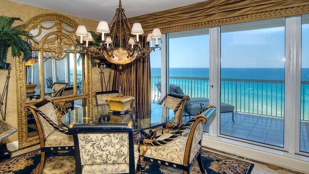 A luxurious dining area with a glass table, ornate chairs, and a view of the ocean. - MAISON PAR LEAU 3 Bedroom Holiday Home by Five Star Properties (Destin)