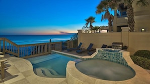 A pool area with a hot tub, lounge chairs, and a view of the ocean at dusk. - Millenia 7 Bedroom Holiday Home by Five Star Properties (Destin)