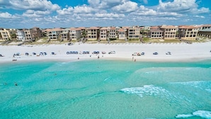 A beach resort with multiple buildings, a sandy beach, and clear turquoise water. - Millenia 7 Bedroom Holiday Home by Five Star Properties (Destin)