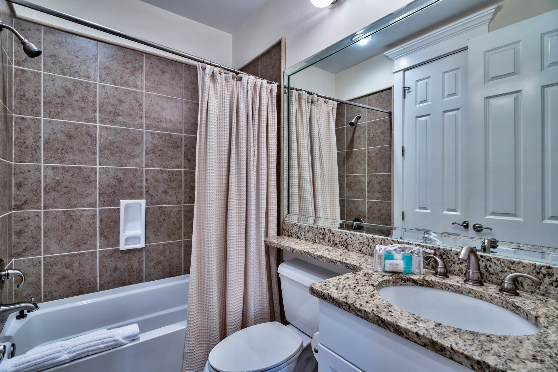 Un baño moderno con bañera, dos lavamanos, inodoro y ducha.