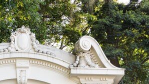 Edifici blanc amb reixetes de ferro ornamentals i un fanal de carrer.