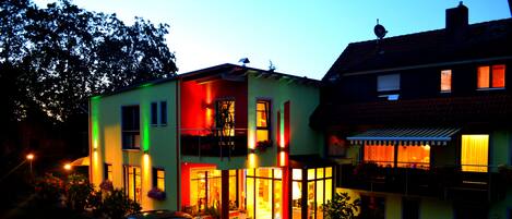 Vista frontal de la propiedad por la tarde o noche