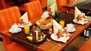 A breakfast table set with a coffee pot, eggs, bread, and juice. - Rothsee Hotel (Allersberg)