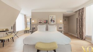 Una habitación de hotel moderna con una cama grande, un escritorio y un banco.