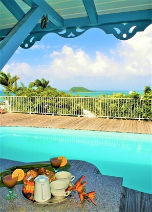 A pool with a view of the ocean, a wooden deck, and a white fence. - Villa prestige Caraïbes Bonheur (Deshaies)