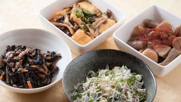 Cuatro tazones con diferentes platos asiáticos, cada uno con ingredientes y guarniciones singulares.