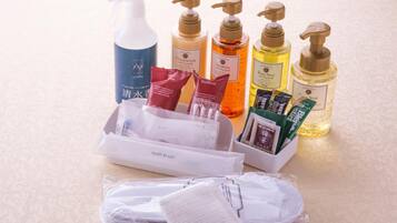 A variety of toiletries including a body soap, shampoo, conditioner, and hairbrushes.
