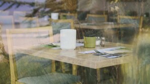 A dining table with chairs, a candle, and a menu. - Akademiehotel Jena (Jena)